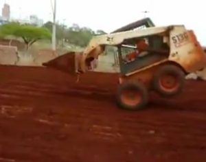 Motorista faz manobras sob duas rodas com trator em obra na Dez de Dezembro